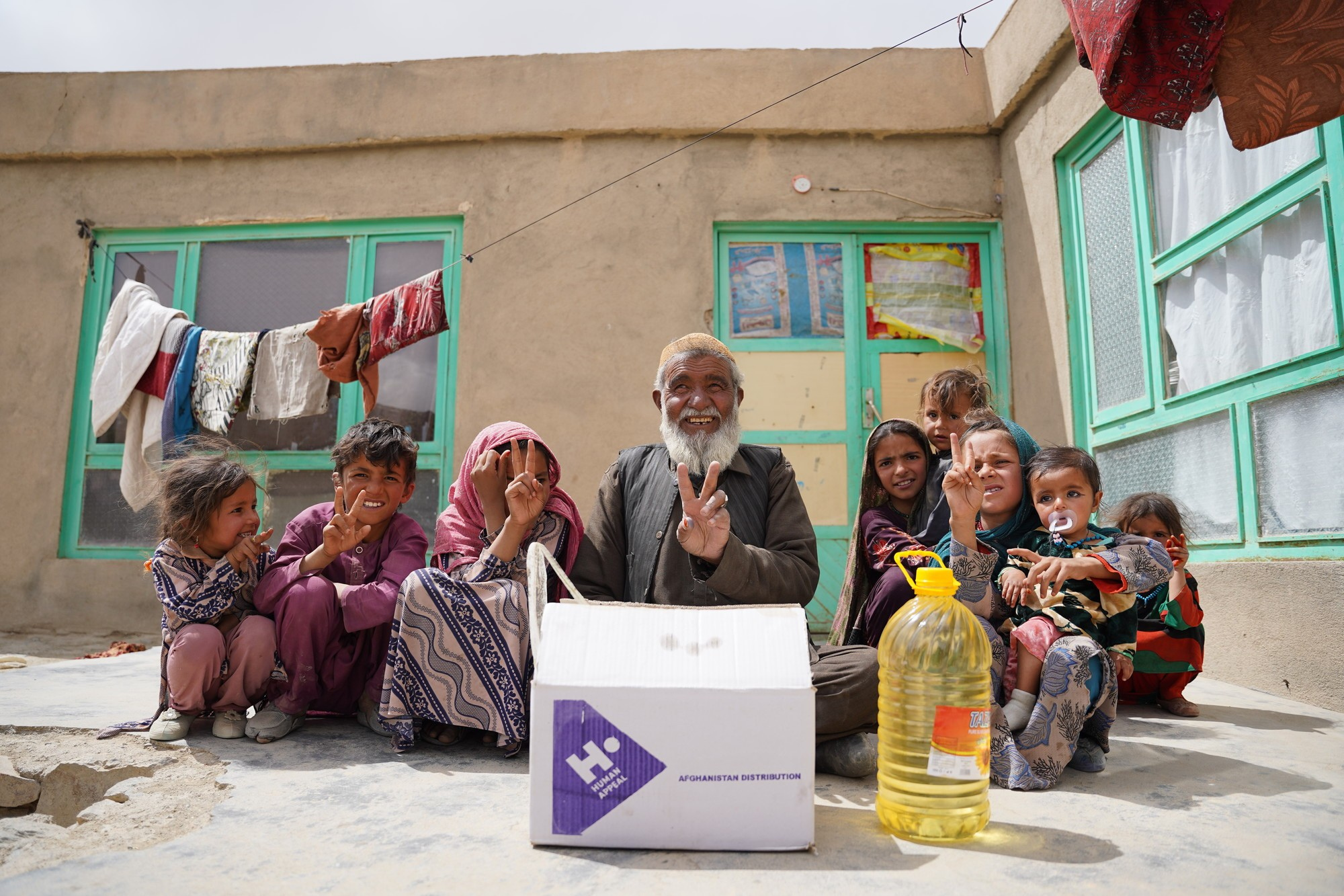 A Human Appeal aid distribution — an elder and children with a Human Appeal food parcel