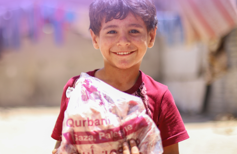 A child holding meat from Qurbani